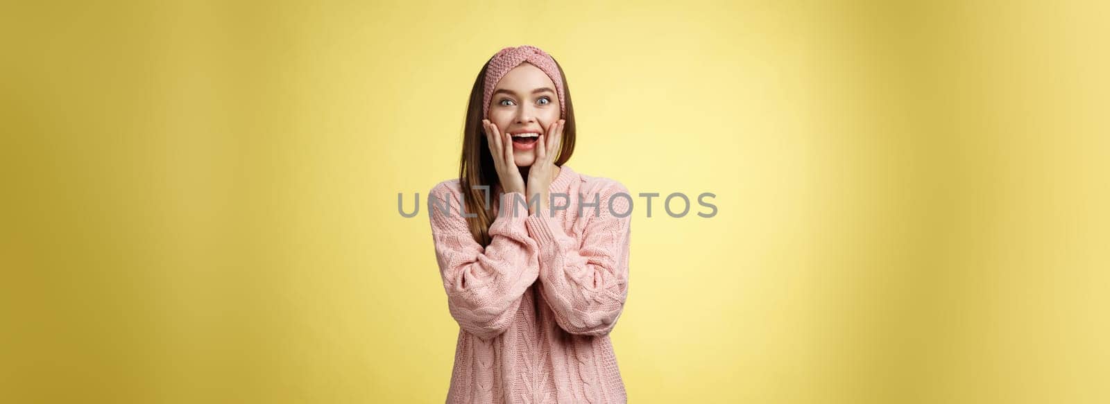 No way, amazing. Ecstatic amazed and amused surprised happy positive glamour young european girl in sweater dropping jaw over fantastic great super news holding palms on cheeks astonished. Copy space