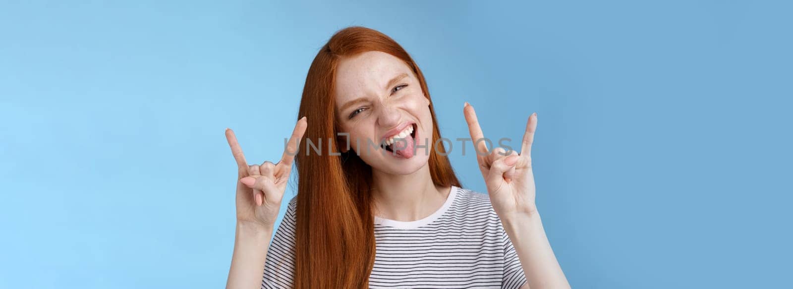 Daring carefree playful excited good-looking funny redhead girl having fun show tongue squinting do thrilled grimace make rock-n-roll heavy metal sign enjoy awesome party cool concert by Benzoix