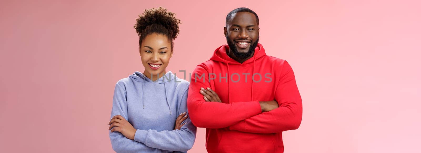 Charming happy professional team two african american man girl smiling broadly self-assured own abilities cross arms chest grinning friendly unbeatable working together, standing pink background by Benzoix