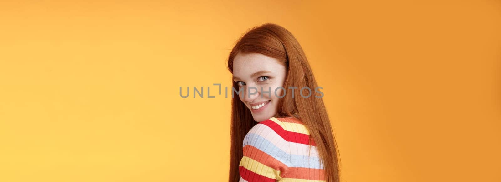 Tenderness, romance, seduction concept. Attractive cheeky flirty young redhead daring girl turn behind look shoulder camera smiling silly coquettish giggle express sympathy affection by Benzoix