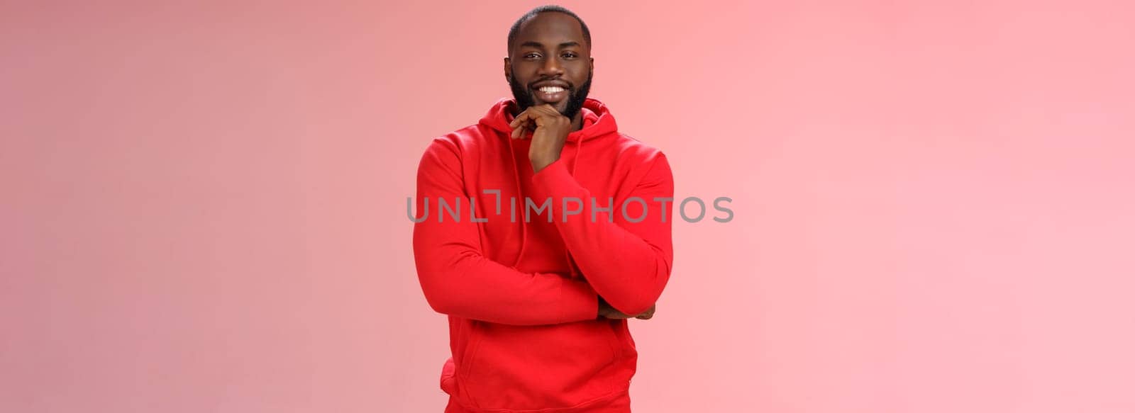 Curious delighted african-american young creative guy thinking new business plan smiling pleased have interesting suggestion rubbing chin thoughtful grinning cross arm chest listening intrigued.