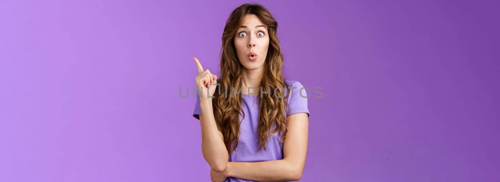 Got it eureka. Excited enthusiastic creative cute european girl raise index finger folding lips wow great found solution suggest perfect plan stand purple background thrilled give good advice.