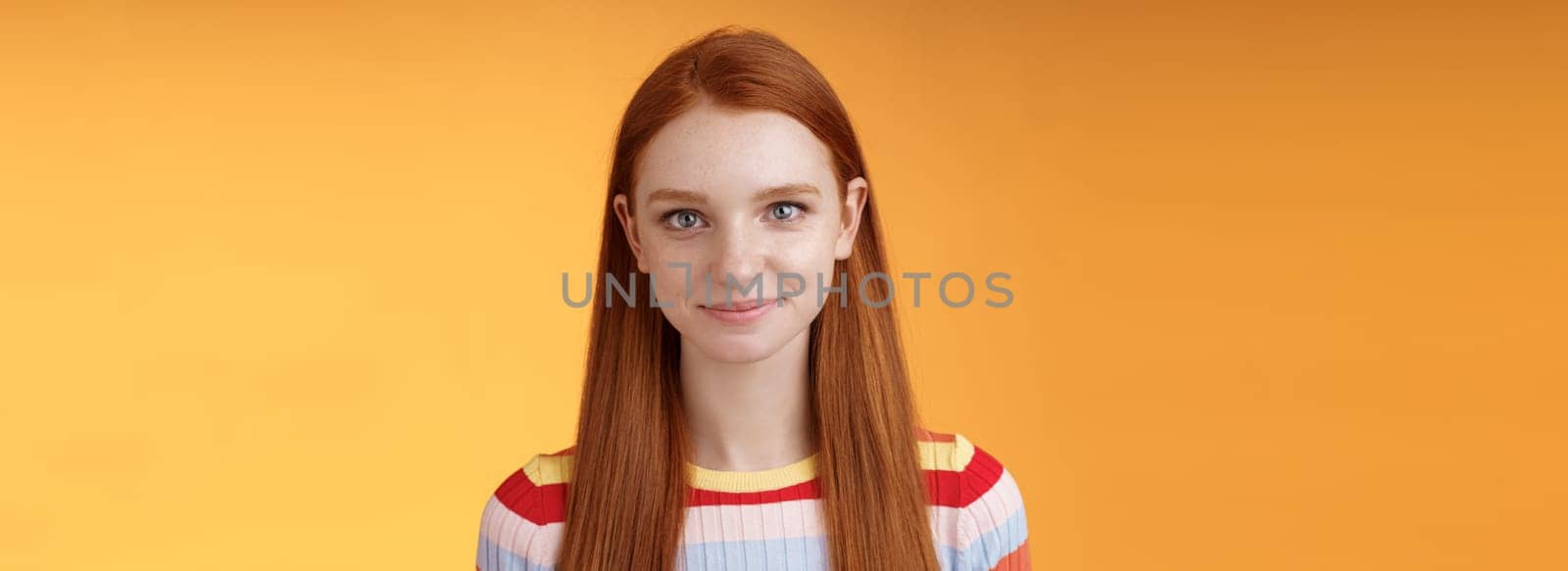 Attractive self-assured redhead girl encouraging herself look mirror confident prepare interview speech standing orange background smirking intrigued listening talking casually by Benzoix