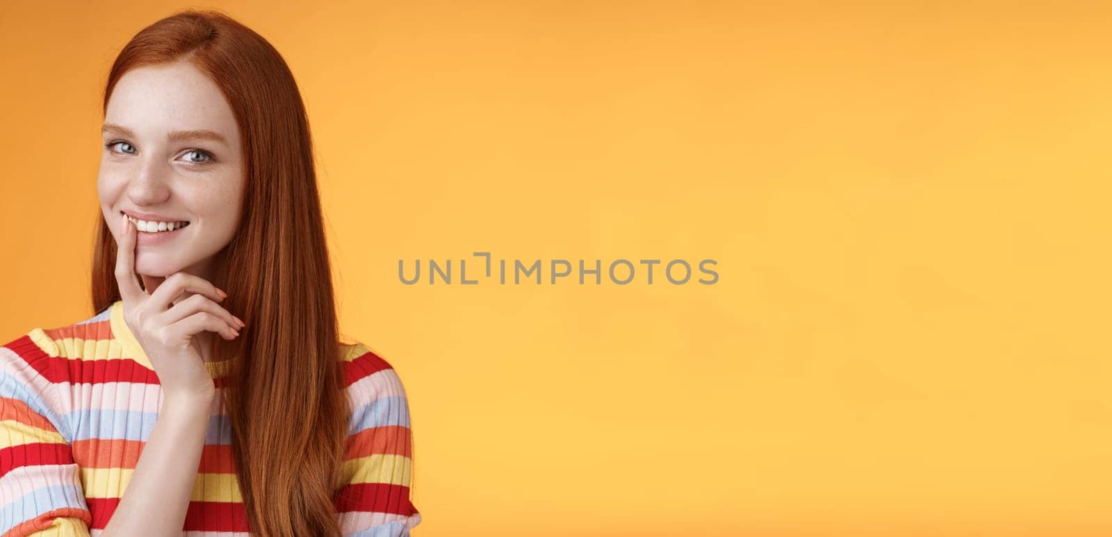 Curious devious redhead young 20s girlfriend have excellent idea smirking tricky touch lip flirty mysteriously glancing camera have plans preparing interesting surprise, standing orange background.