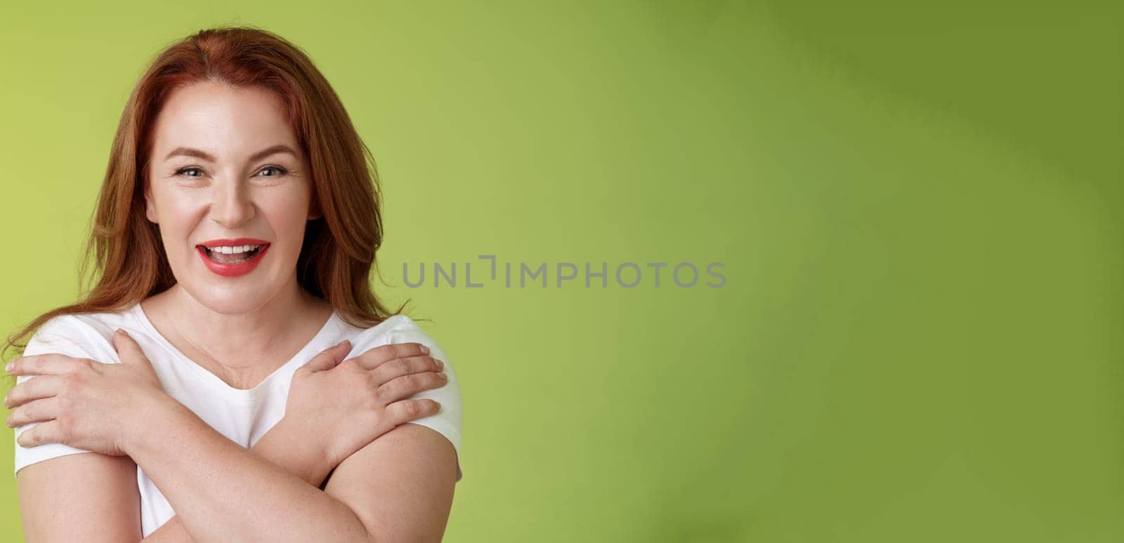 Cheerful charismatic happy good-looking redhead woman red lipstick cross hands chest smiling motivated excited having fun playful thrilled mood grinning enthusiastic standing green background by Benzoix