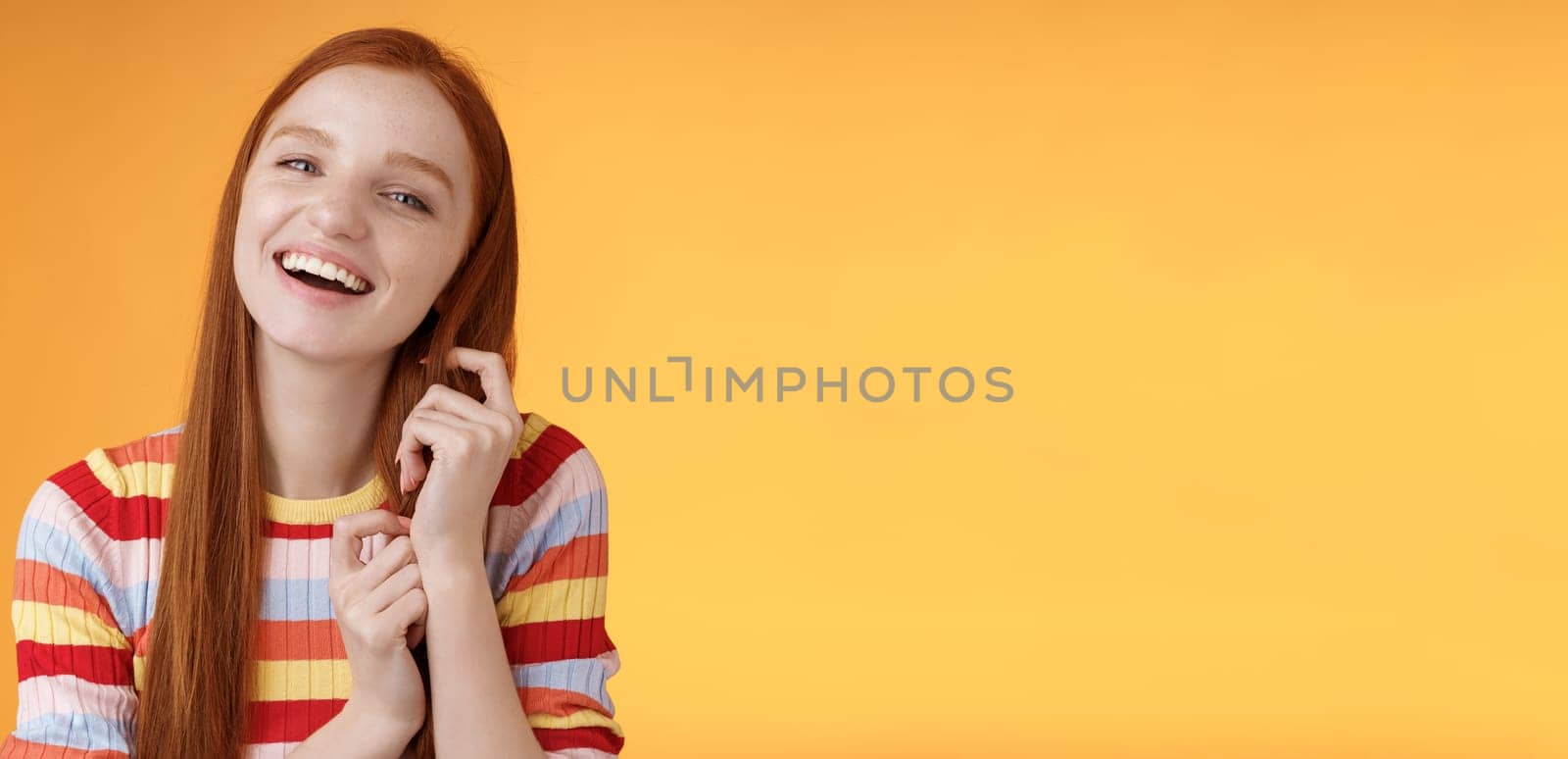 Silly good-looking flirty lively redhead young girl laughing playing coquettish ginger hair strand chuckling amused funny boyfriend jokes having fun awesome romantic date, orange background by Benzoix