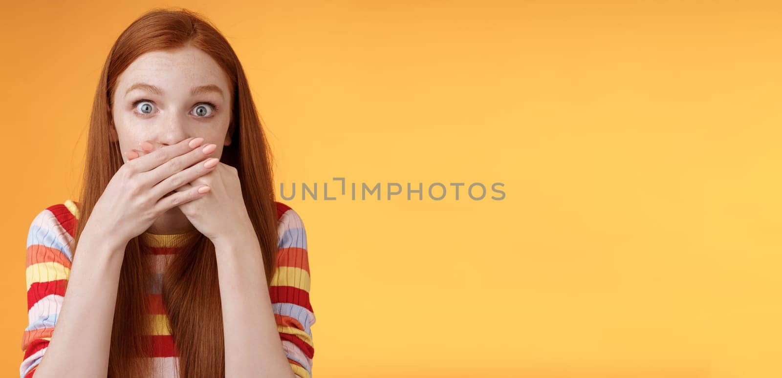 Oops sorry. Girl feeling awkward saying inappropriate word standing unconfident cover mouth palms wide eyes staring camera shocked express surprise nervously standing orange background by Benzoix