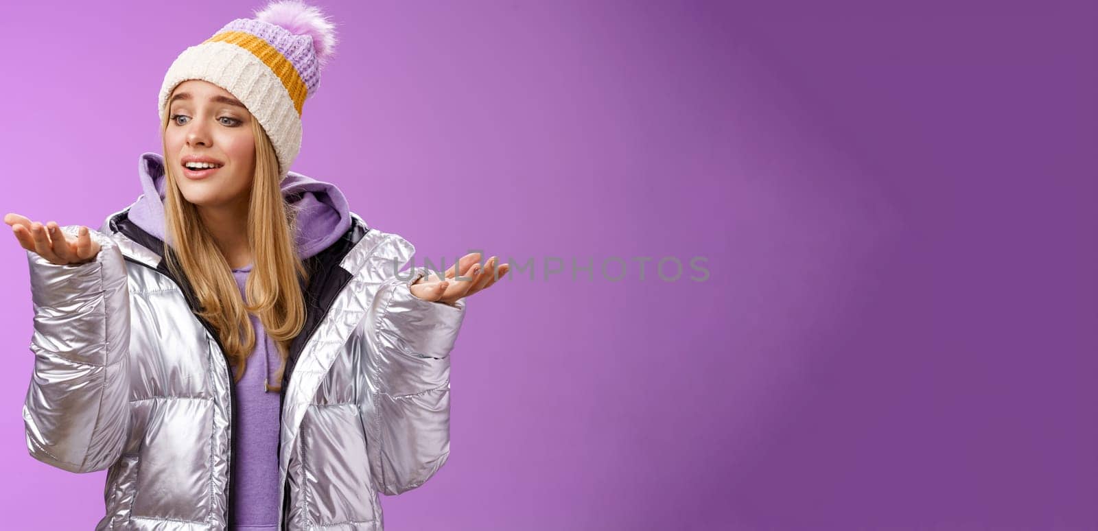 Delighted caring lovely young blond woman looking snowflake drop palm glancing hand tenderly smiling cherish nice moment enjoying winter snowy day standing pleased purple background.