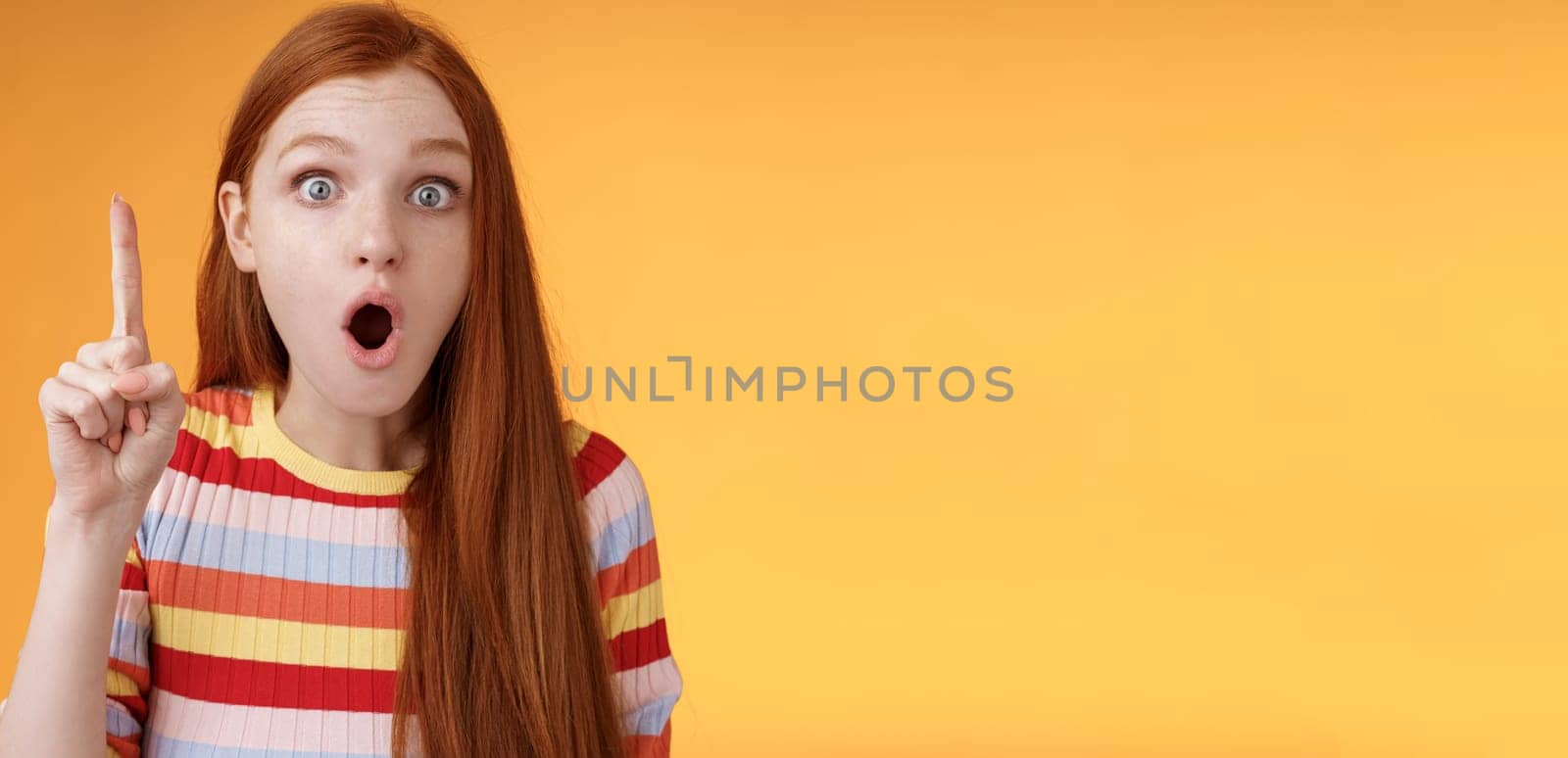 Wow got excellent idea. Excited shocked redhead girl open mouth raise index finger eureka gesture stare camera thrilled adding suggestion have plan think-up solution, standing orange background.