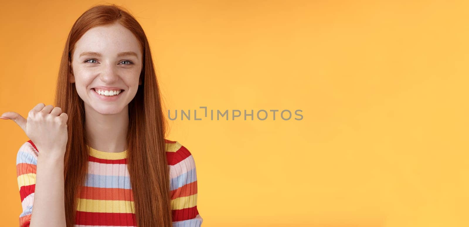 Girl pointing left cool person can help smiling delighted look friendly camera discuss interesting project introduce friend during conversation standing happy grinning orange background by Benzoix