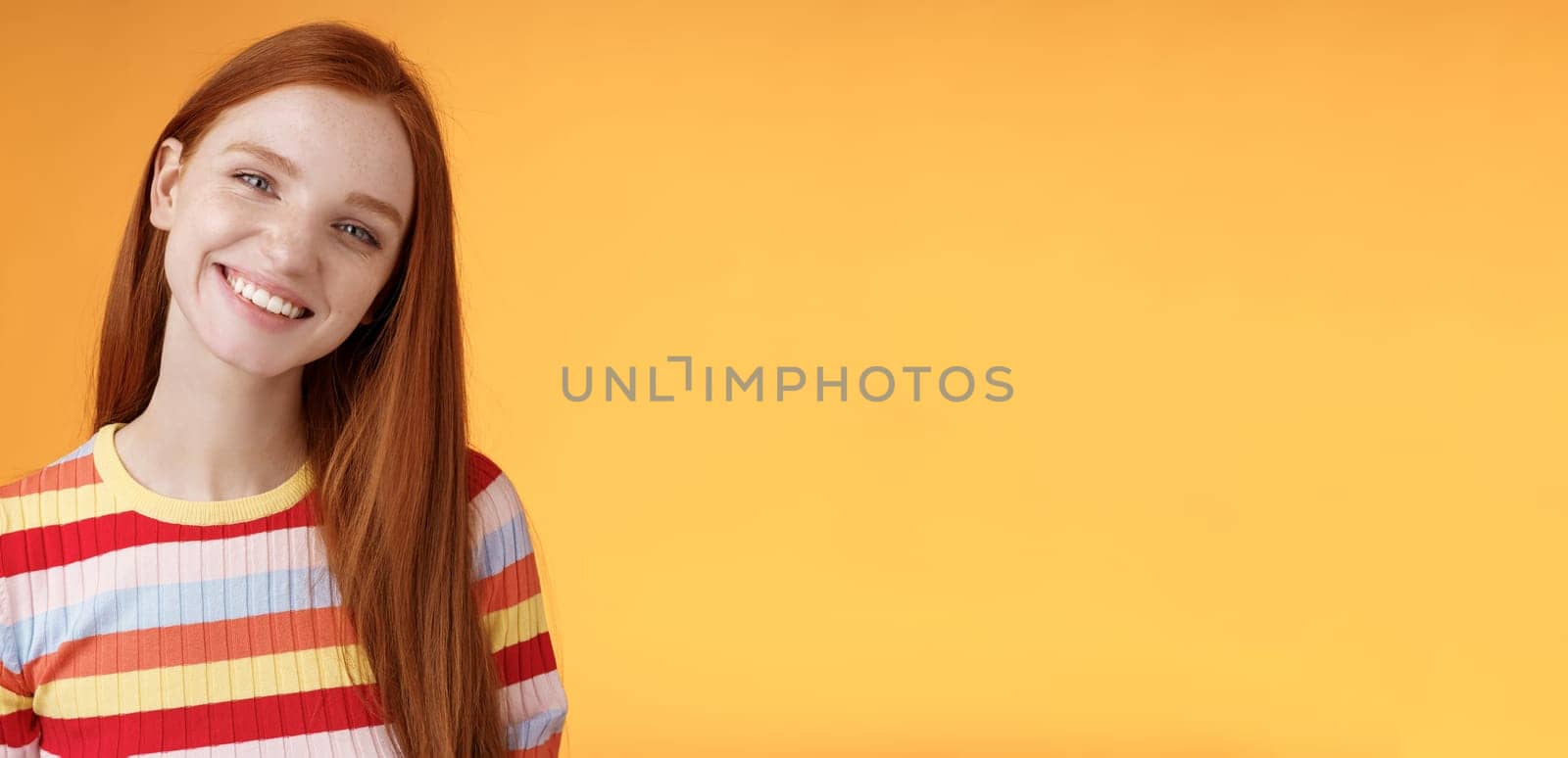 Pleasant charismatic young confident carefree redhead charming girl tilting head smiling broadly white teeth talking casually good mood express positive happy emotions standing orange background by Benzoix