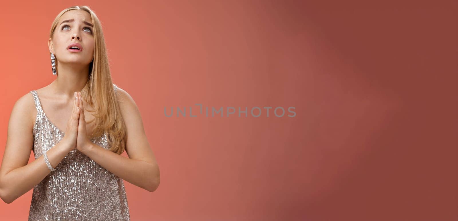 Hopeful worried concerned faithful blond woman in silver dress praying talking god wishing family okay press palms together supplicating nervously begging, standing red background stylish dress by Benzoix