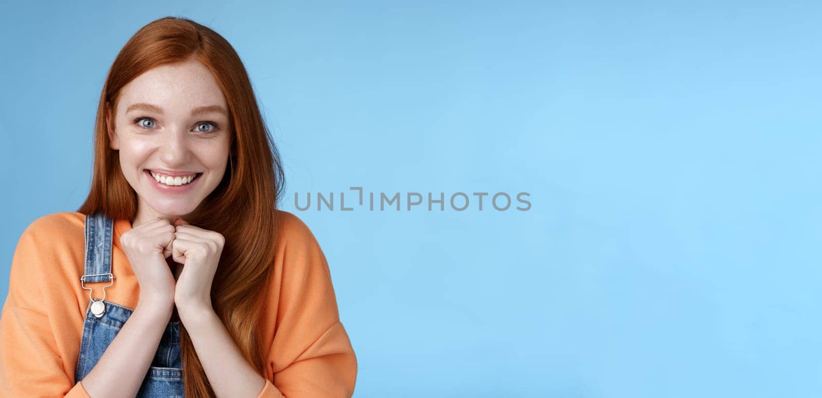 Cute attractive excited smiling happy redhead girl blue eyes freckles receive awesome opportunity study abroad grinning rejoicing very grateful look thankful surprised camera, blue background by Benzoix