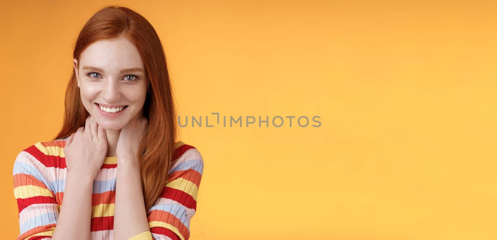 Pleased happy tender feminine redhead gorgeous girl blushing flirty giggle gazing camera smiling broadly touching neck modesy shy sensually talking guy likes standing orange background silly by Benzoix