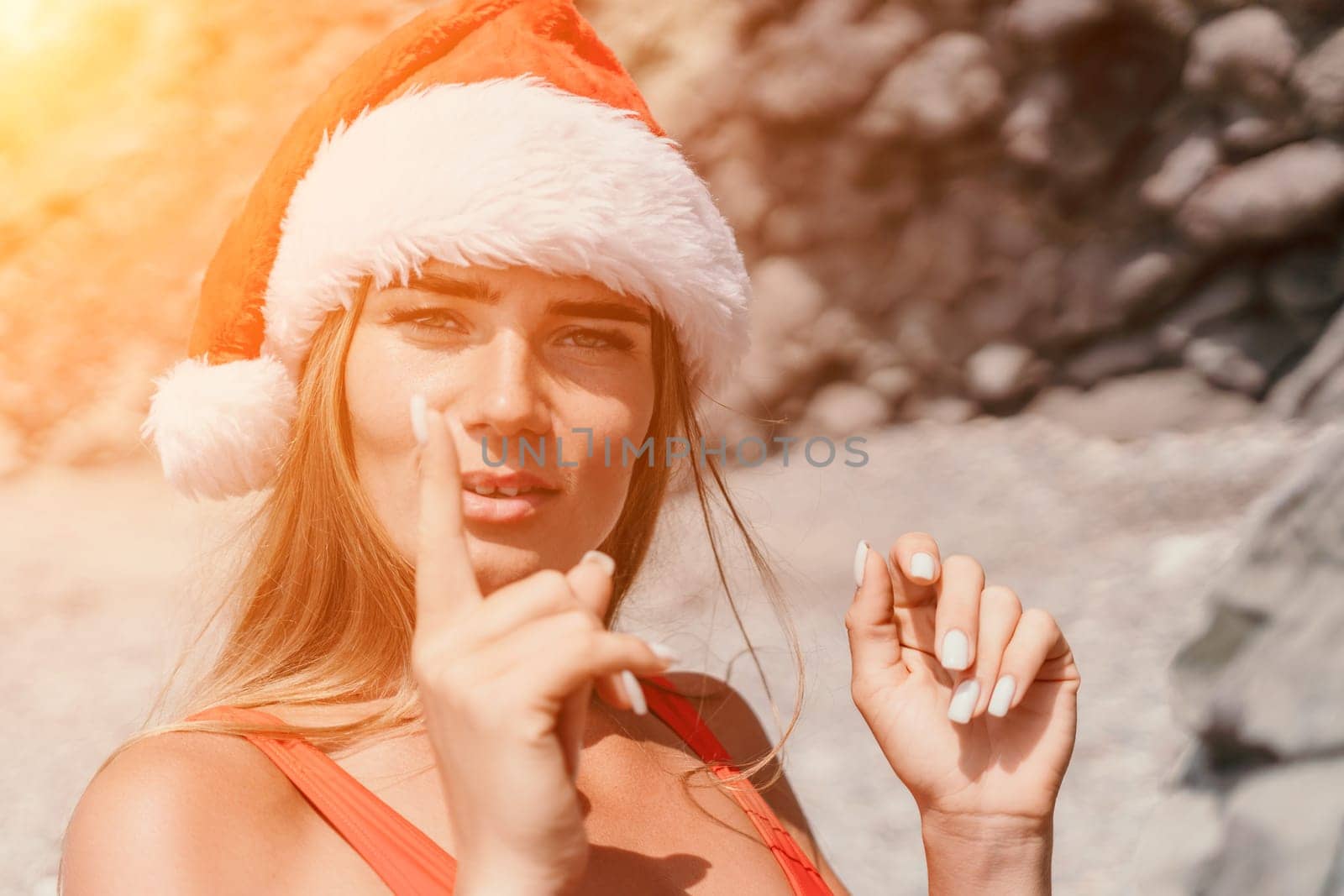 Woman travel sea. Young Happy woman in a long red dress posing on a beach near the sea on background of volcanic rocks, like in Iceland, sharing travel adventure journey