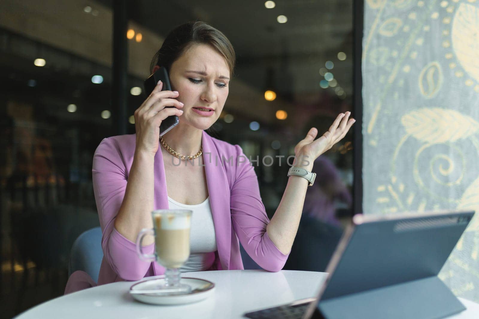 When business doesn't go according to plan. Upset business woman emotionally talking on the phone in a cafe by Rom4ek