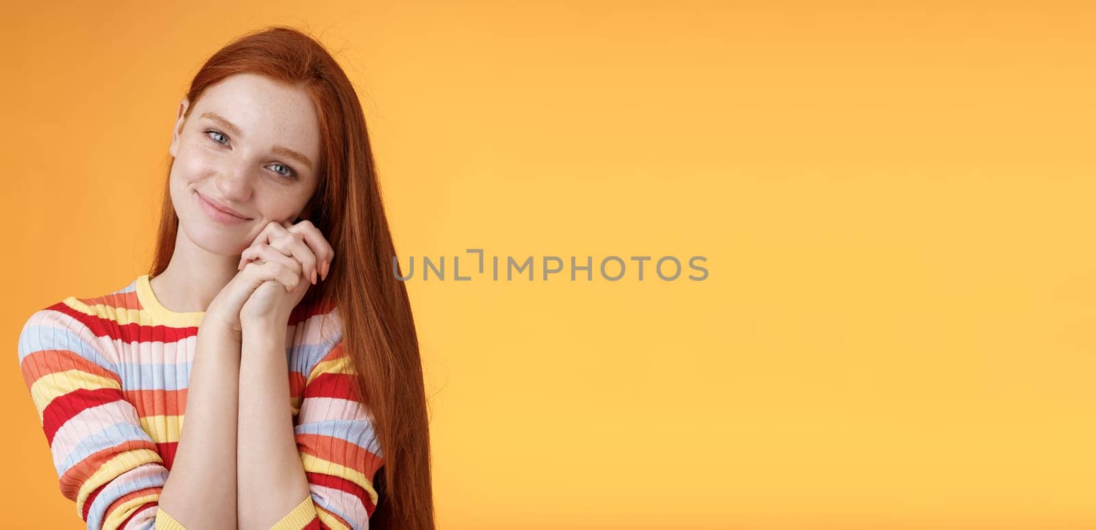 Dreamy sensual romantic young passionate redhead girlfriend melt heart feel sympathy joy receive sweet tender present lean palms smiling grateful gladly accept nice lovely gift, orange background by Benzoix