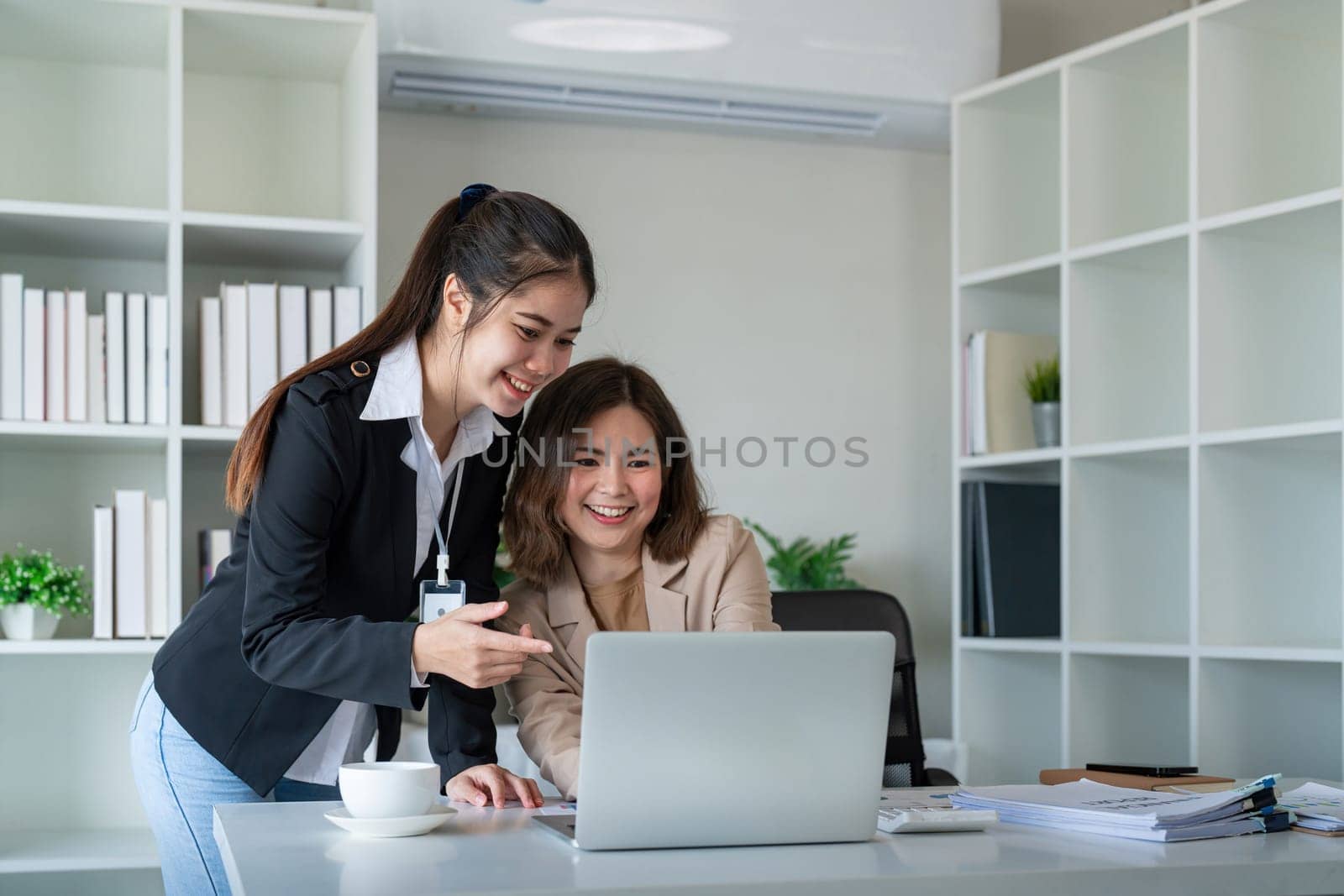 Two businesswoman discussing partner discussing project on laptop in office. Two colleague of professional business people working together at workspace by nateemee