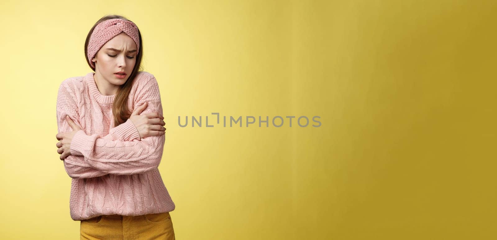Brr girl freezing, turn-on heater. Portrait of timid cute woman wearing knitted sweater trembling from cold, embracing herself on arms looking down, stooping from discomfort cool temprature by Benzoix