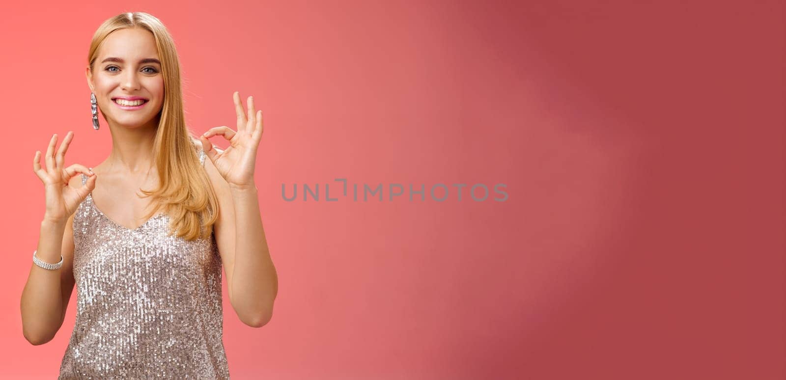 No problem friend. Charming carefree tender blond european woman in silver dress show okay ok gesture smiling pleased recommend awesome party assure having fun, feel excellent red background.