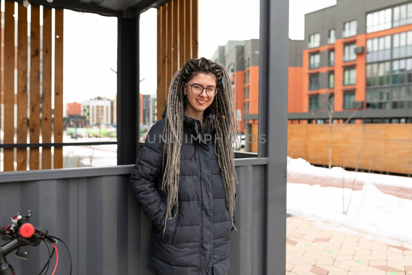 Lifestyle concept, a young pretty European woman with pigtails dressed in a warm winter jacket walks around the city.