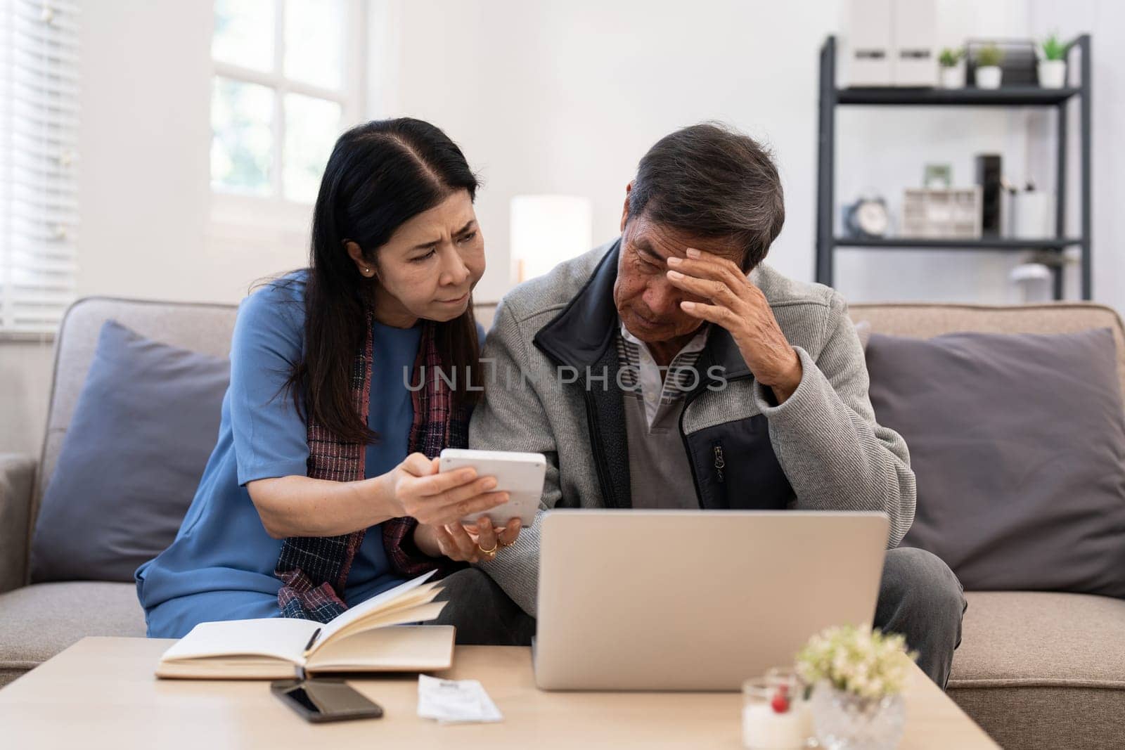 Serious stressed asian senior old couple worried about bill discuss unpaid bank debt paper payment worry about money problem.