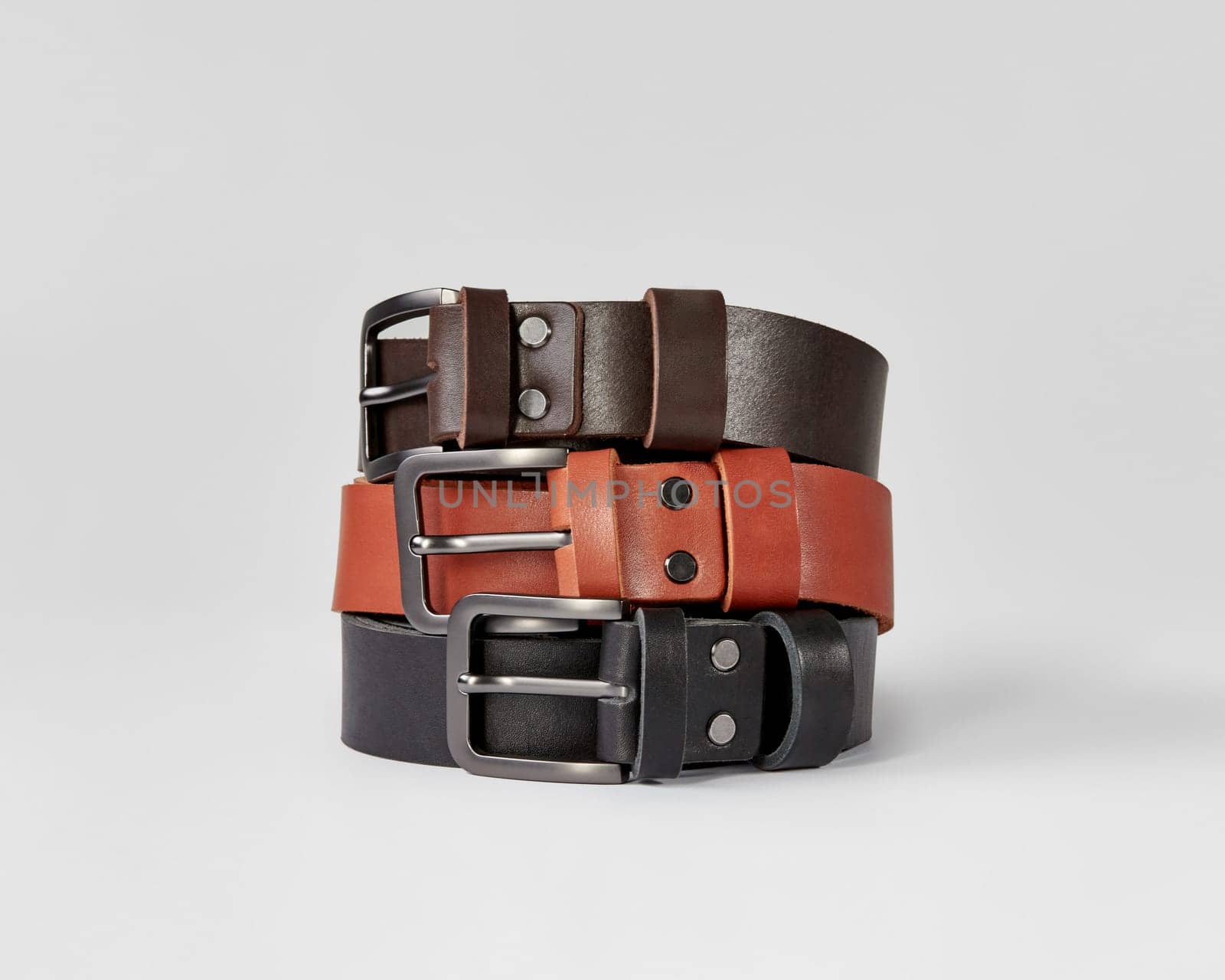 Three folded leather belts of different colors with DAD embossing by nazarovsergey