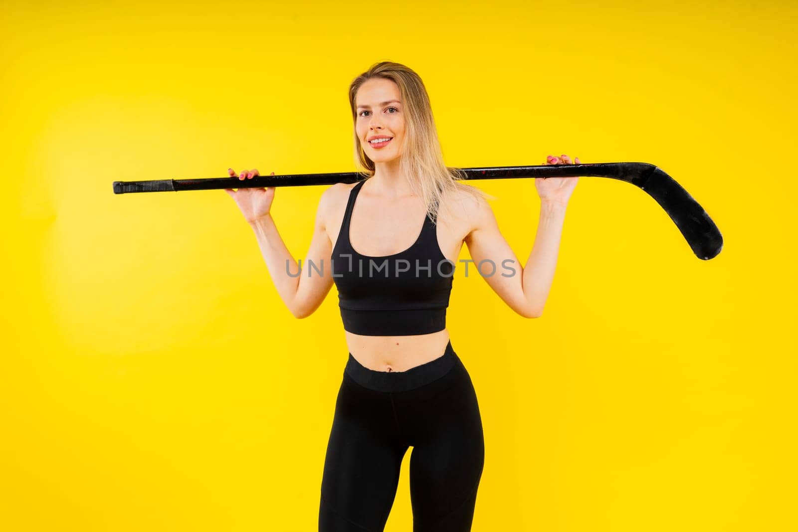 Ice hockey fan female in sports wear with hockey stick in studio by Zelenin