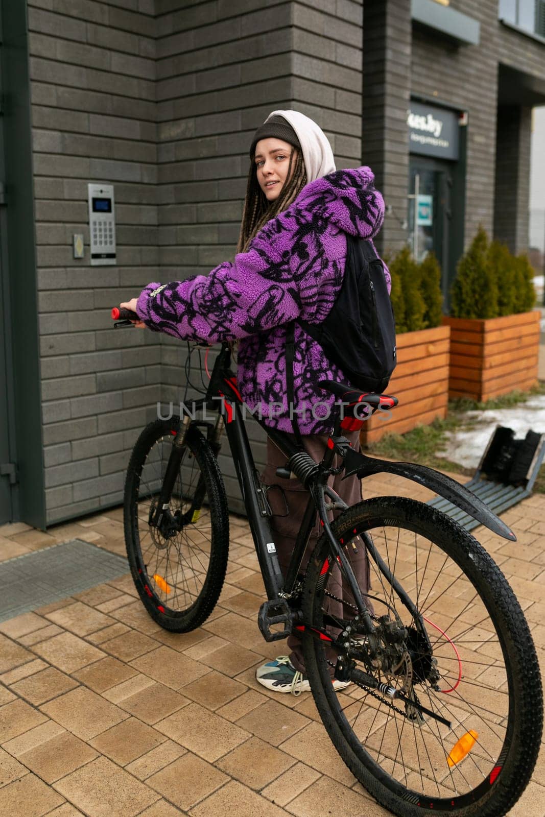 Bicycle rental concept. A young woman with dreadlocks spent a walk around the city riding a bicycle.
