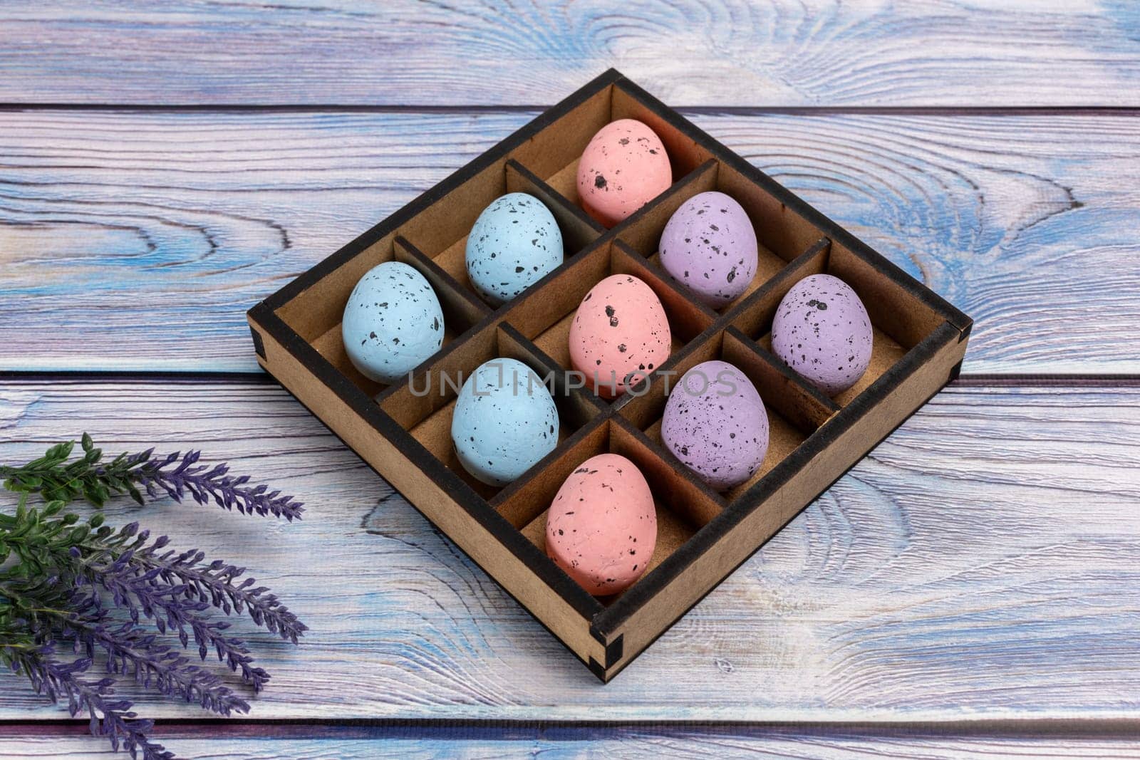 Colorful Easter eggs in a box on the wooden background by mvg6894