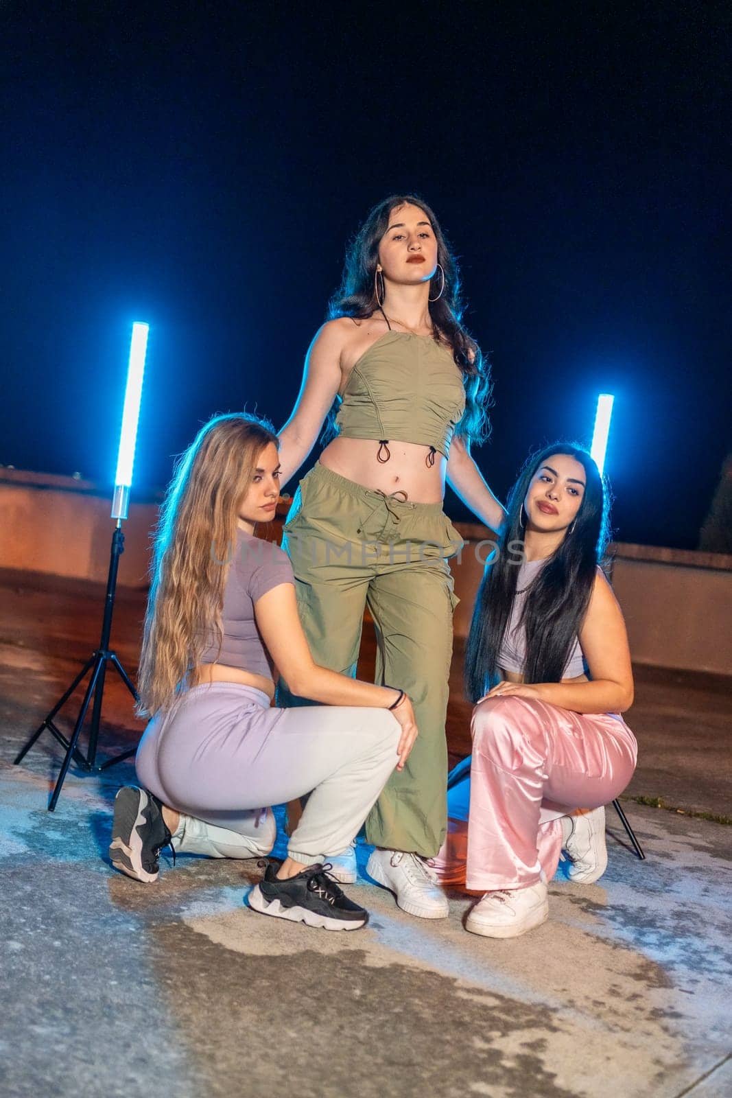 Portrait of three teen trap dancers outdoors at night by Huizi