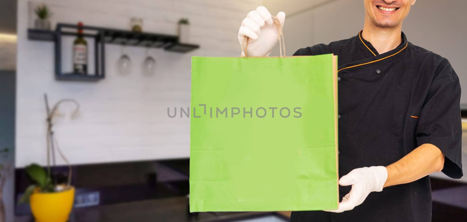 box with fast food being carried by delivery man in uniform for one of clients by Andelov13
