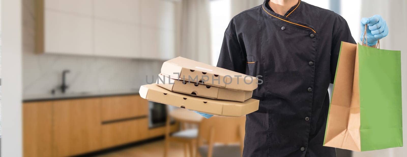 Paper pocket and food containers in hands of a smiling deliveryman. .Quality service of a restaurant