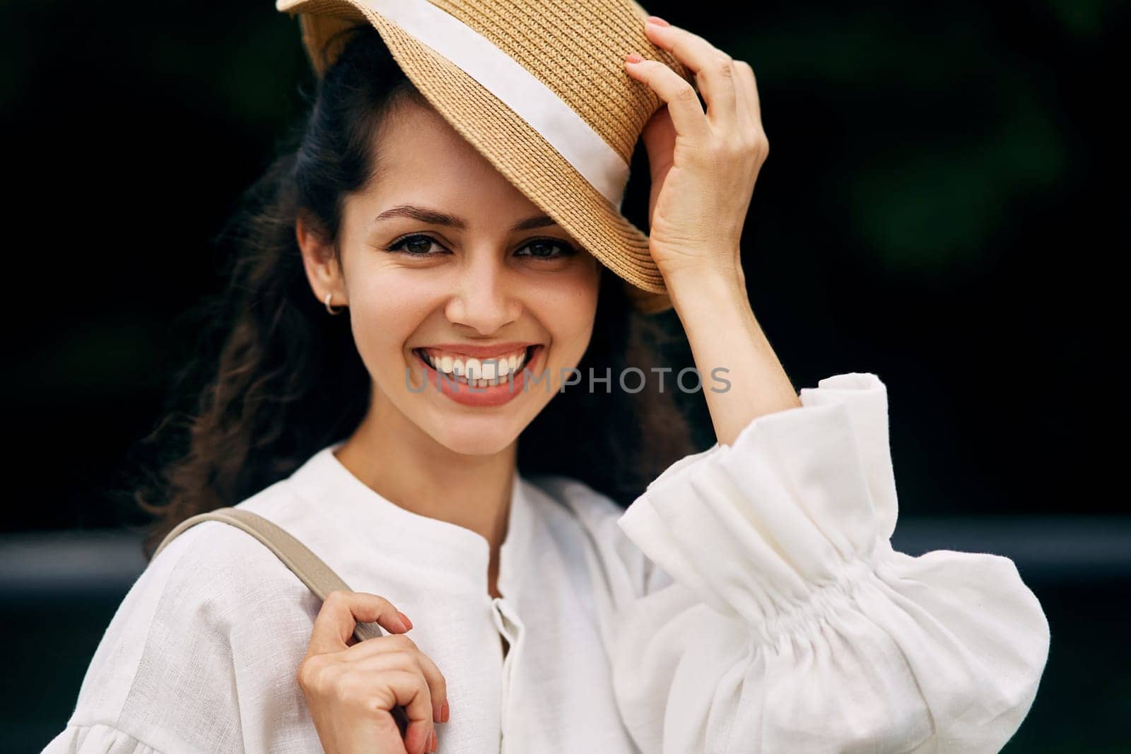 Portrait of a smiling curly-haired brunette girl in a hat by driver-s