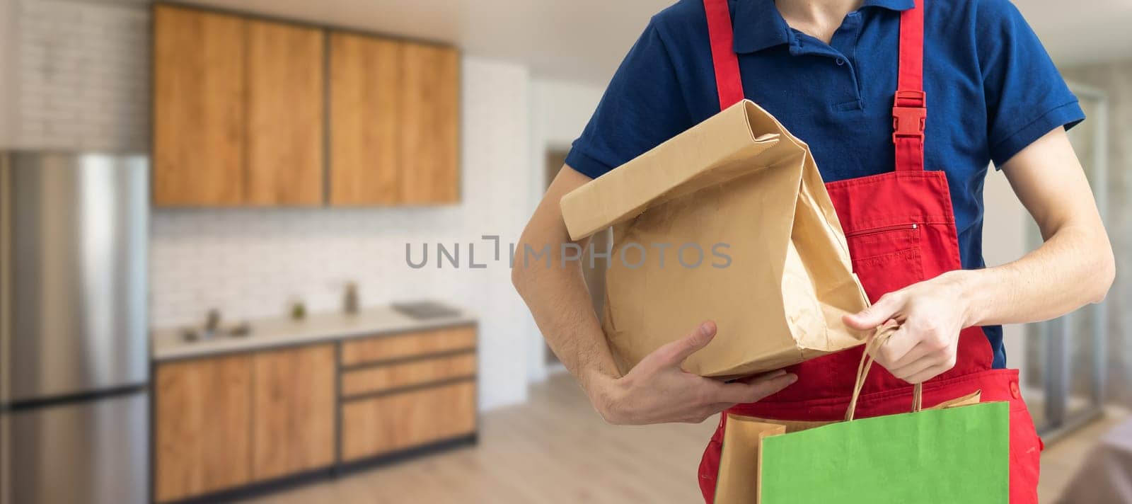 Diverse of paper containers for takeaway food. Delivery man is carrying pizza by Andelov13