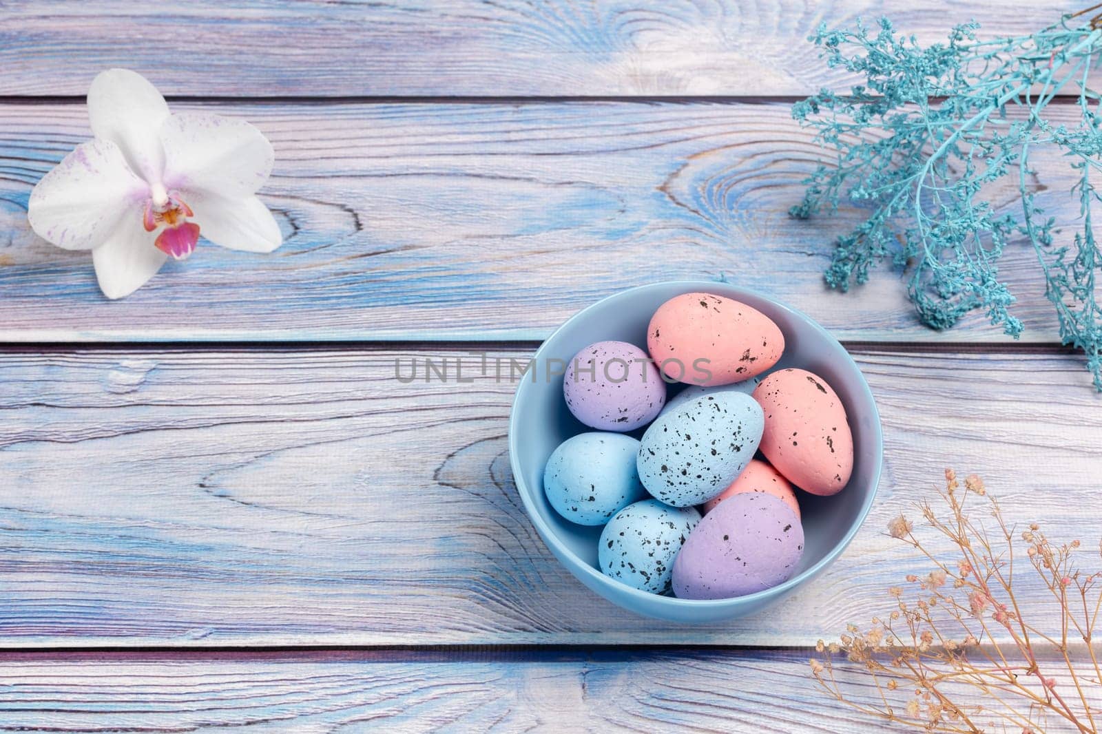Bowl with colored Easter eggs on the wooden background. by mvg6894