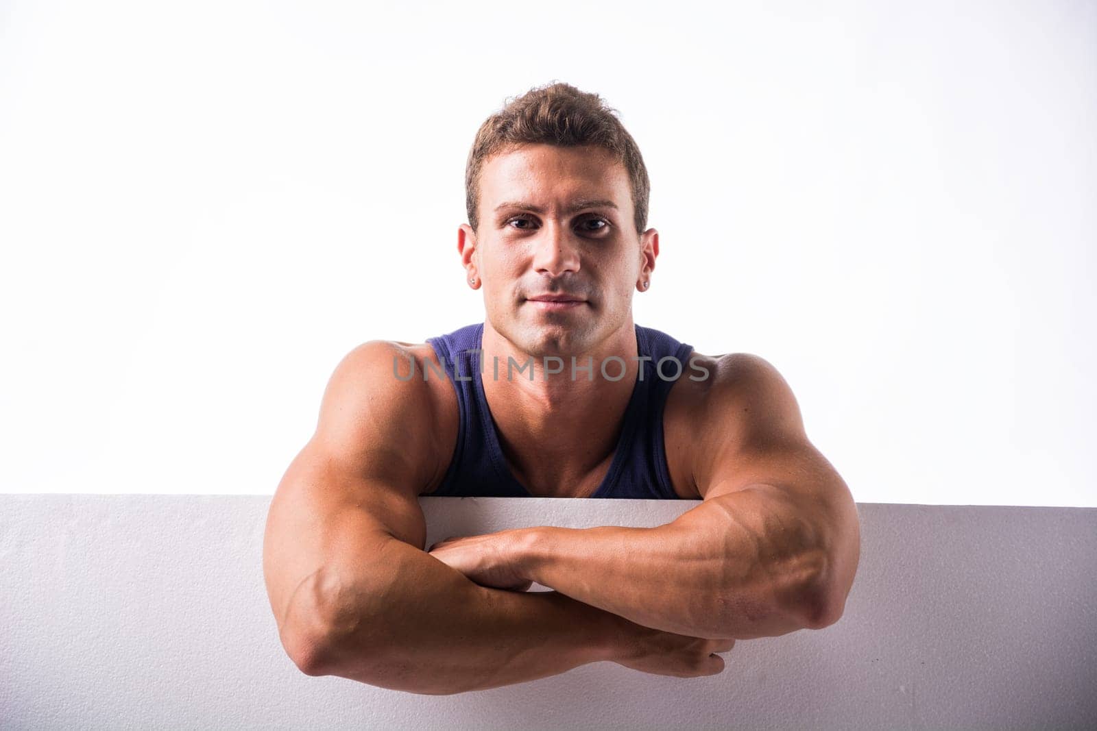 A man is standing in a pose with his arms crossed, looking directly at the camera. He appears confident and assertive in his stance.