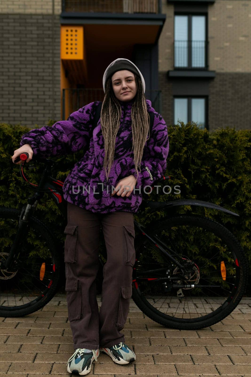 Athletic young woman enjoys cycling in the cold season by TRMK