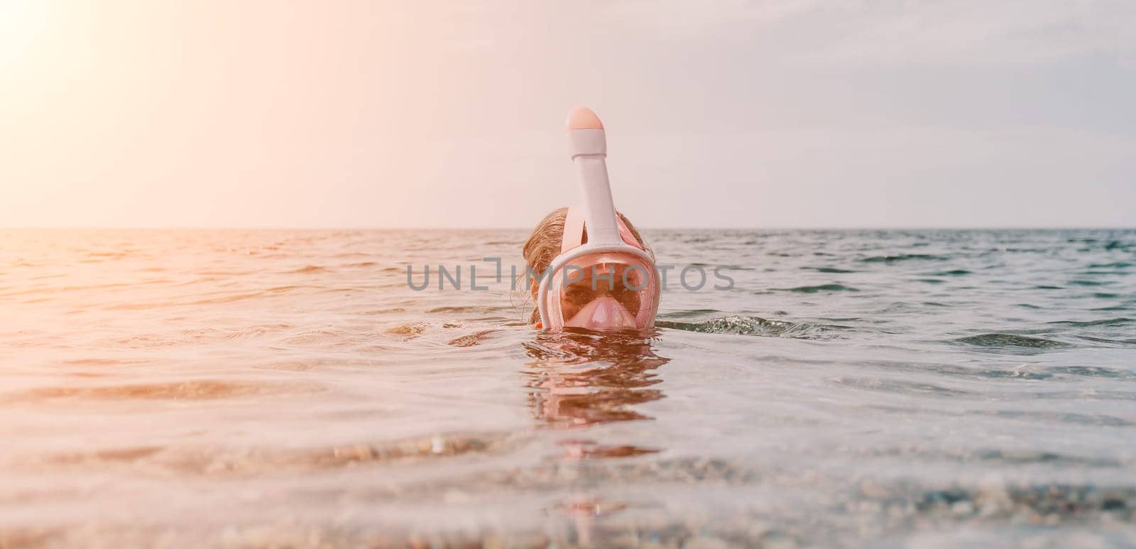 Young happy woman in white bikini and wearing pink mask gets ready for sea snorkeling. Positive smiling woman relaxing and enjoying water activities with family summer travel holidays vacation on sea. by panophotograph