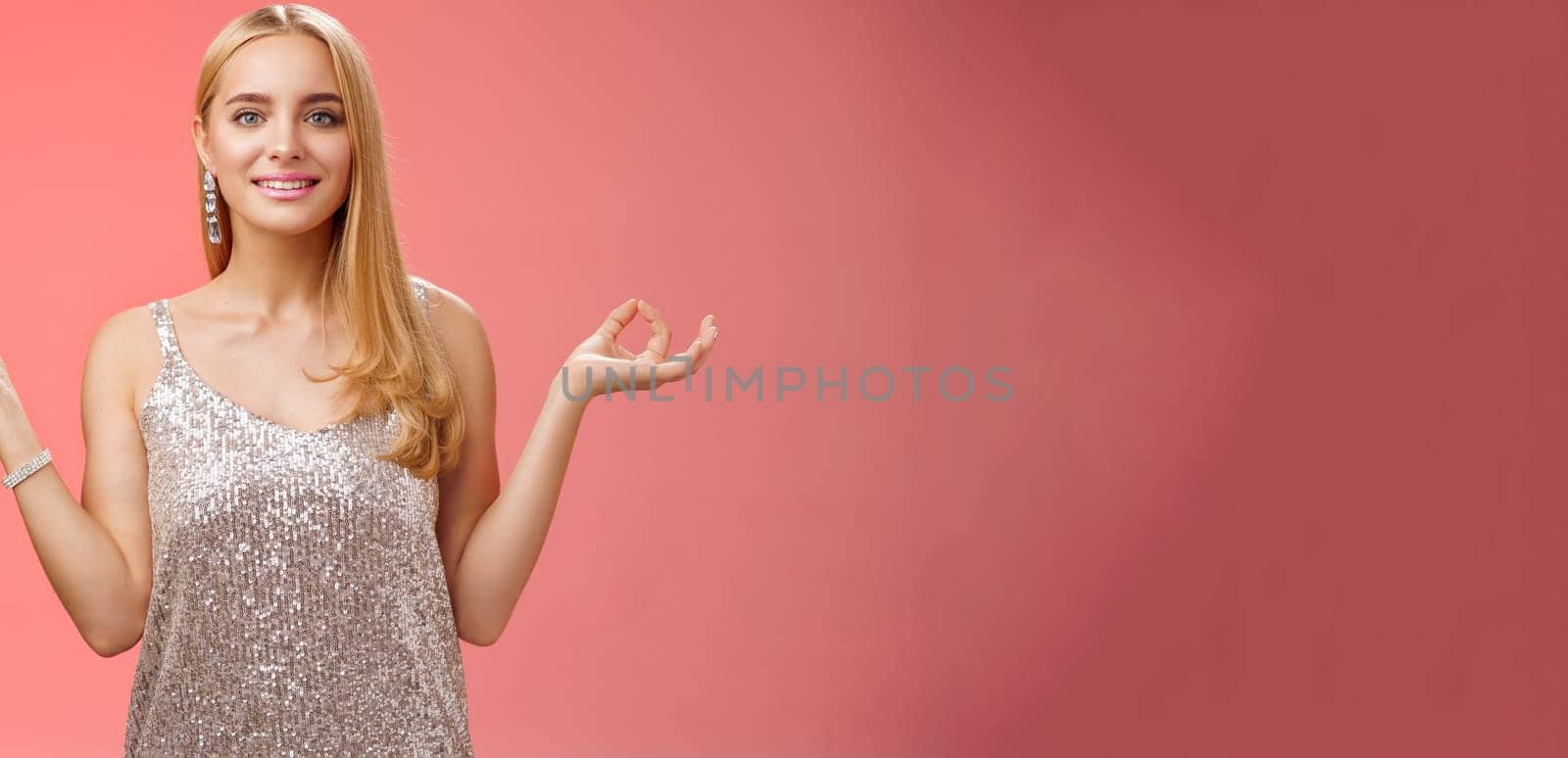 Lifestyle. Calm relieved happy fabulous young blond woman in silver stylish luxury dress standing relaxed red background zen lotus pose reach nirvana smiling peaceful carefree meditating breathing practice.