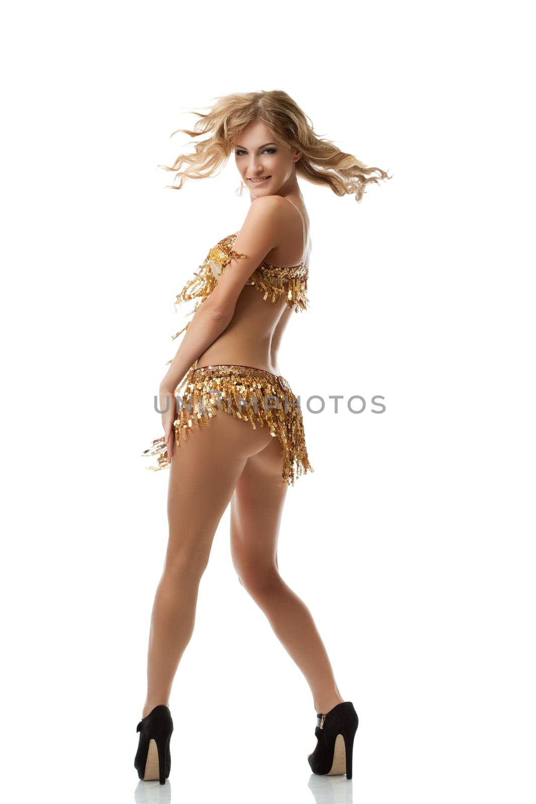 Flirtatious dancer of rumba turned at camera, isolated on white