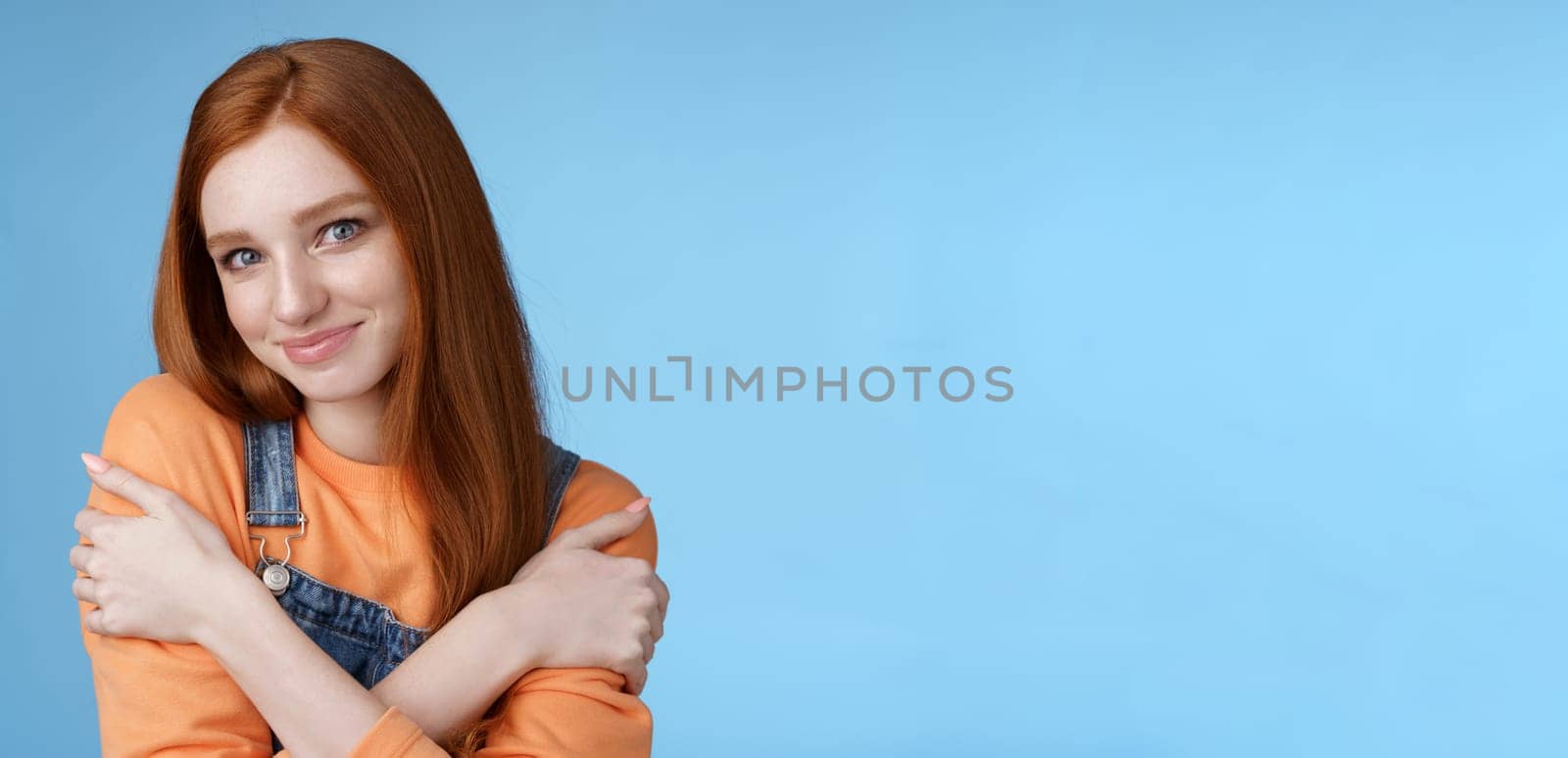 Romantic sensitive flirty young redhead girlfriend feel warmth embraces hugging herself hands crossed body tilting head smiling safe gentle, dreaming lovely date recalling sensual moments.