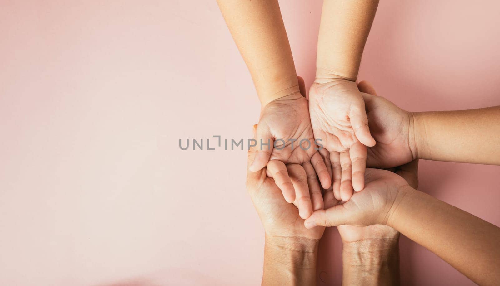 Celebrating family day, Parents and kid holding empty hands together isolated on a color background. Space for text. by Sorapop