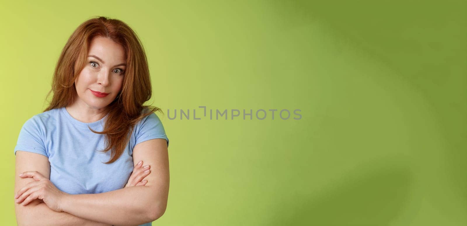 Confused shocked redhead mother look serious worried puzzled cross arms chest self-soothing calming gesture stare camera perplexed frustrated bad son behaviour stand green background disappointed by Benzoix