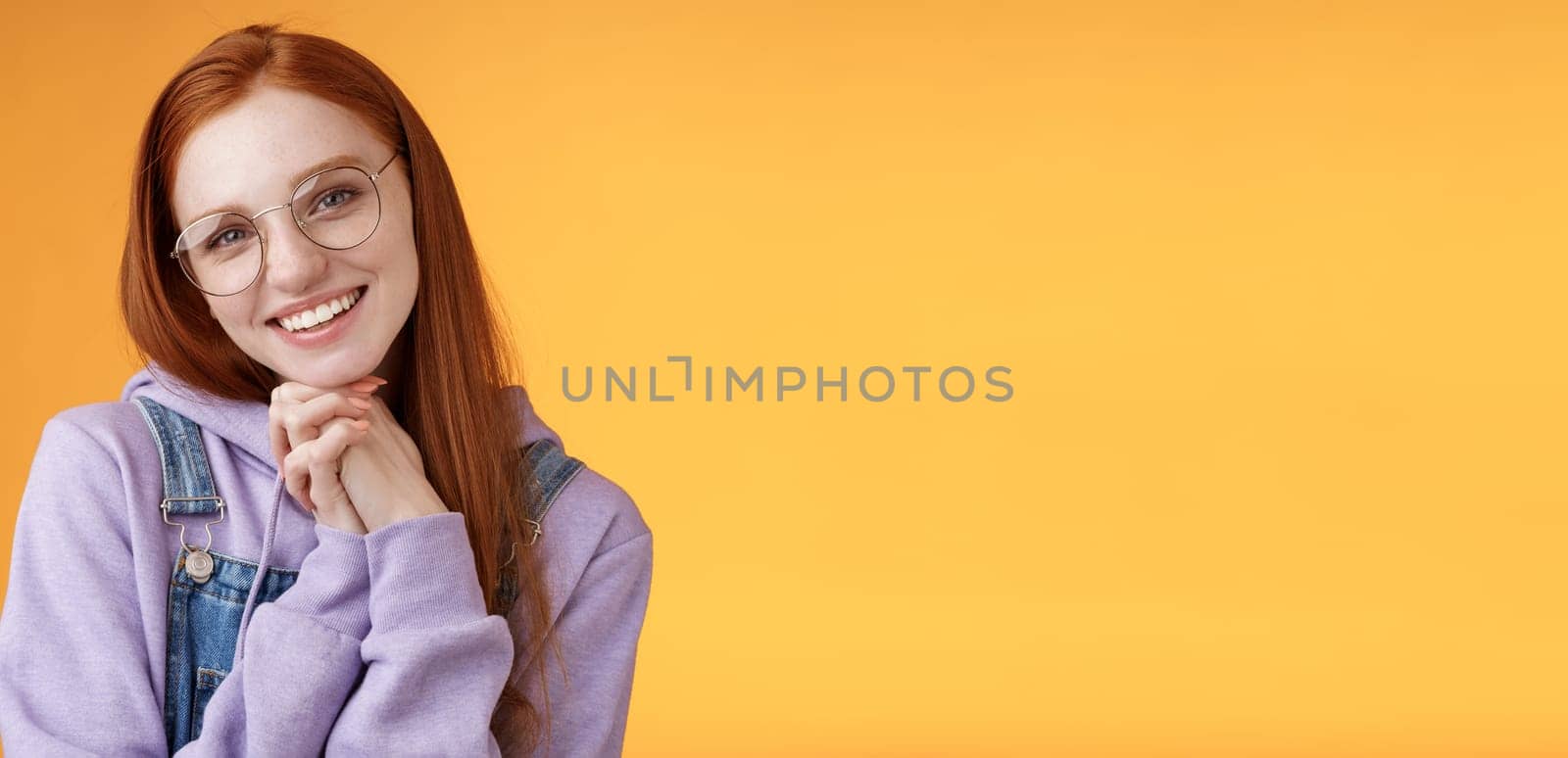 Tender romantic lovely redhead girlfriend leaning palms tilting head cute flirty giggling smiling camera white teeth wearing glasses hoodie overalls near orange background, sensually laughing by Benzoix