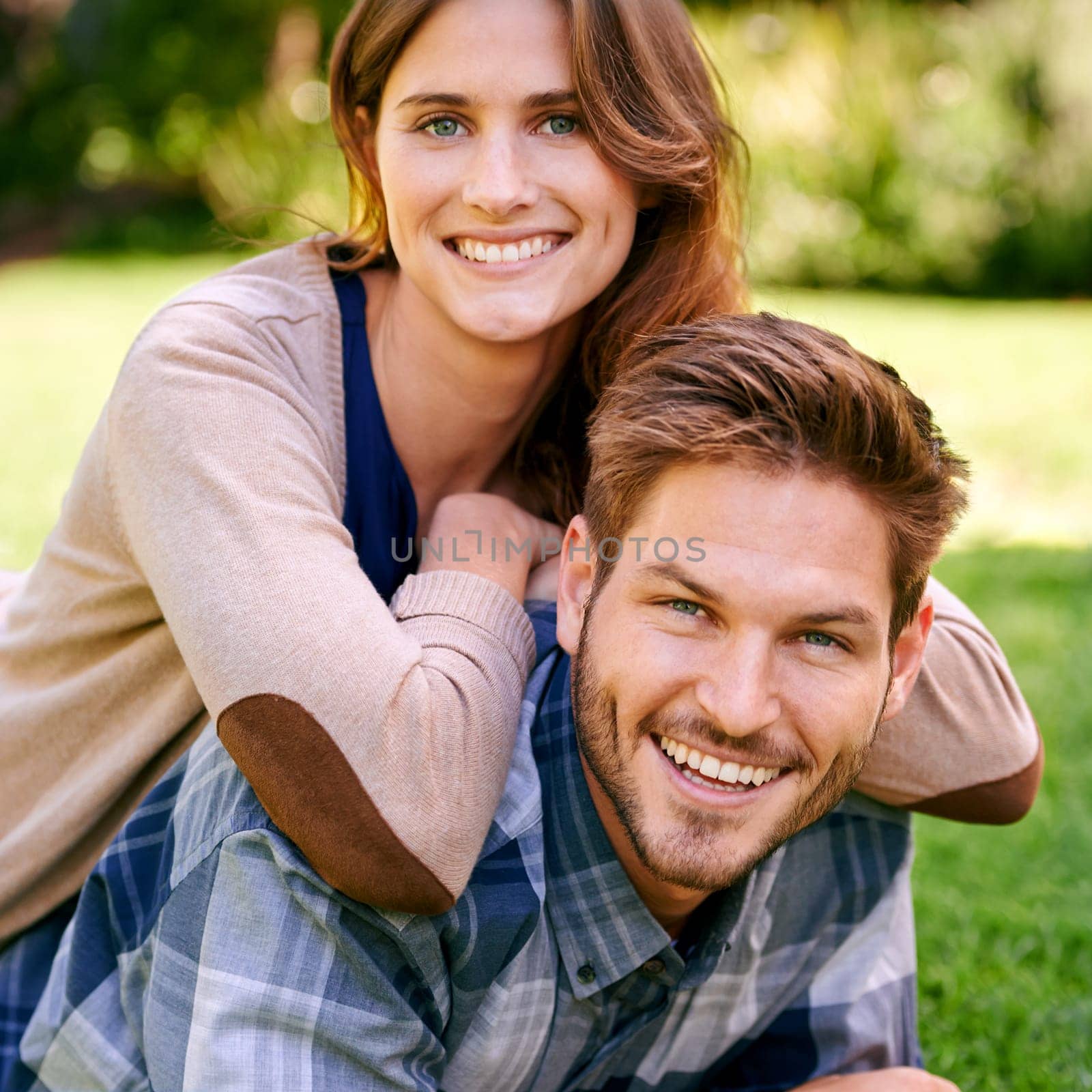 Happy, couple and smile on lawn together, laying and summer portrait to relax in natural environment. Love, family time for caring on holiday and relationship growth, attractive and garden date.
