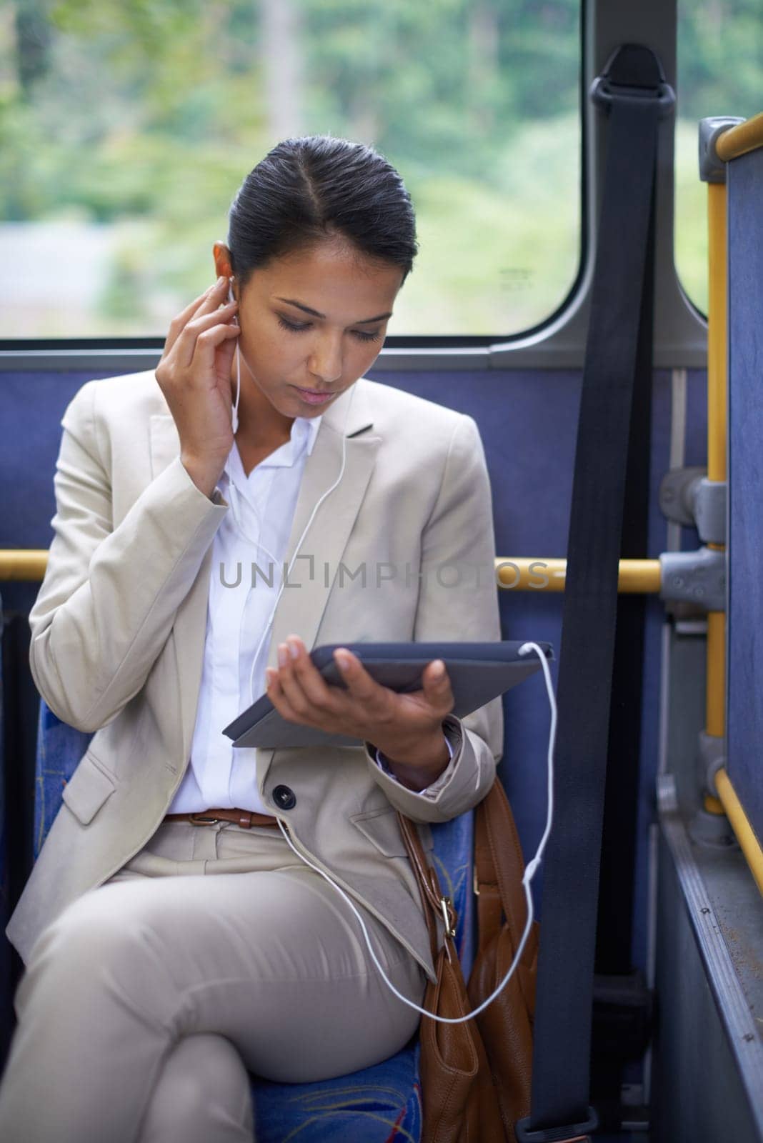 Woman, streaming and travel on bus with tablet and earphones for journey and transport in outdoor. Business person and research with formal clothes and tech online for communication and commute.
