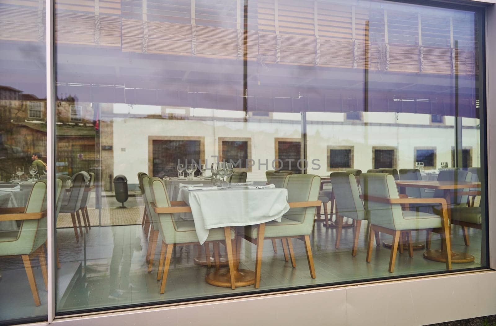 A restaurant building with tables and chairs is visible through a large window, showcasing its interior fixtures and furniture