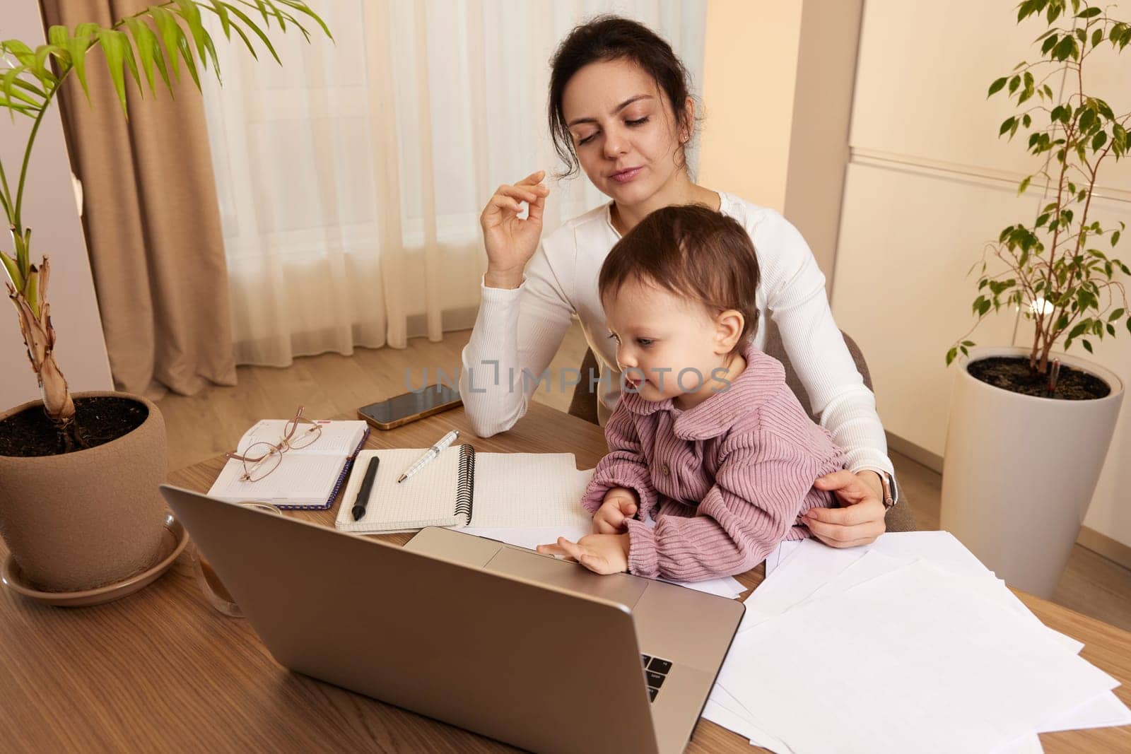 businesswoman working at home with her little child girl by erstudio