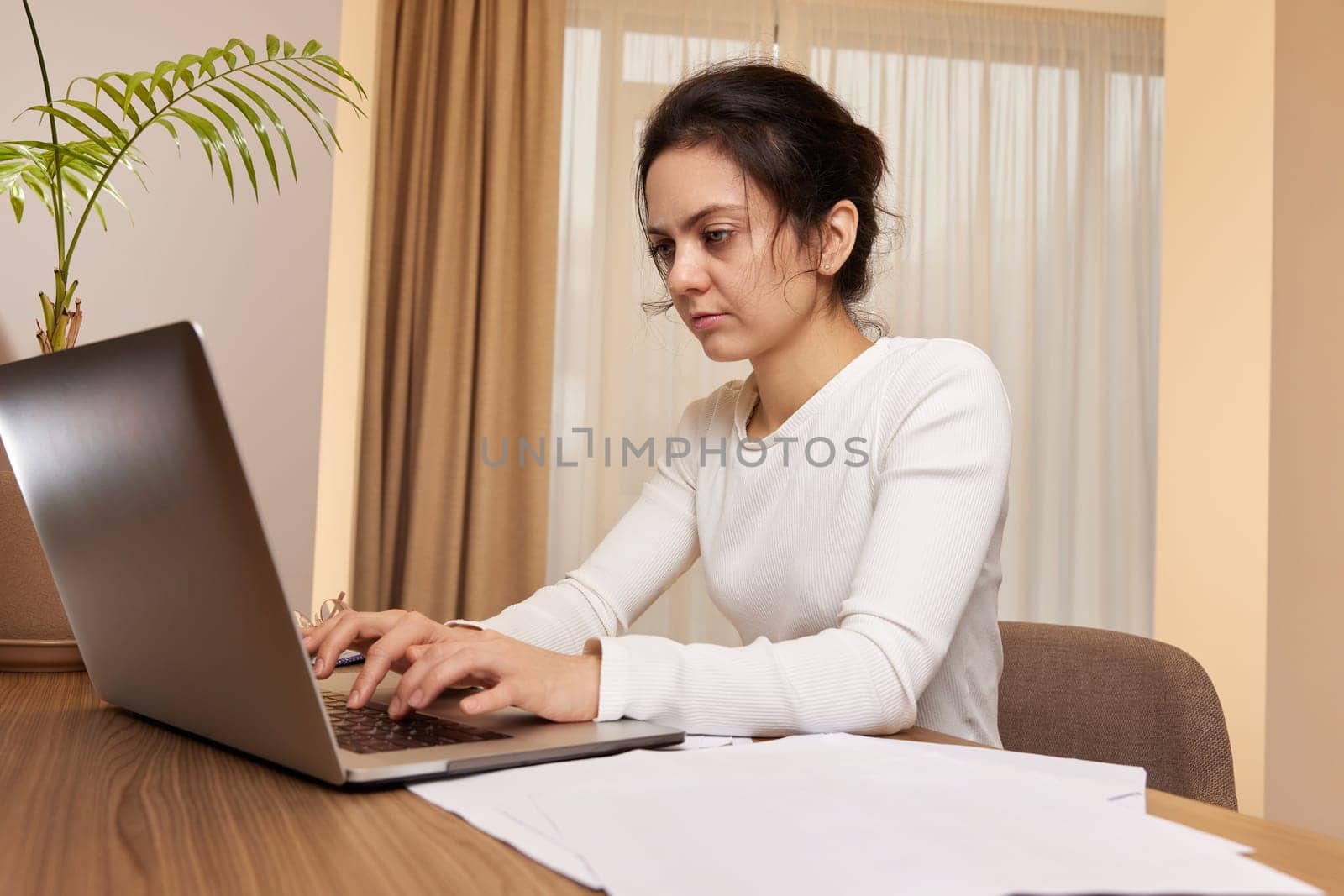 beautiful businesswoman using laptop and communicates with customer on internet at home